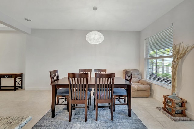 tiled dining room with an inviting chandelier