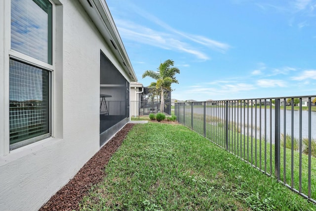 view of yard featuring a water view and a sunroom