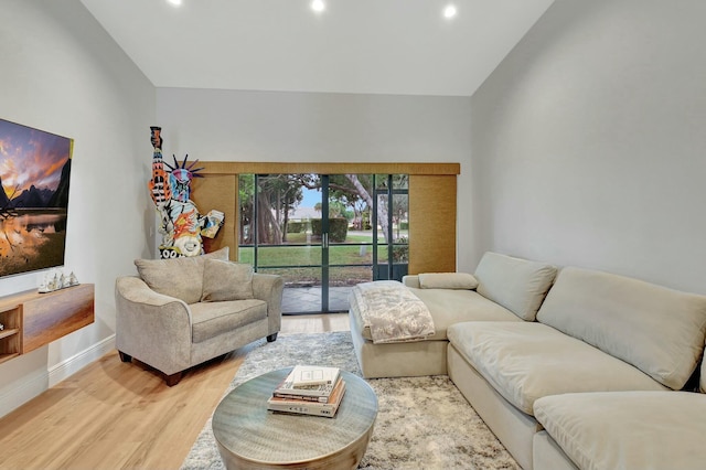 living room with light hardwood / wood-style floors and vaulted ceiling