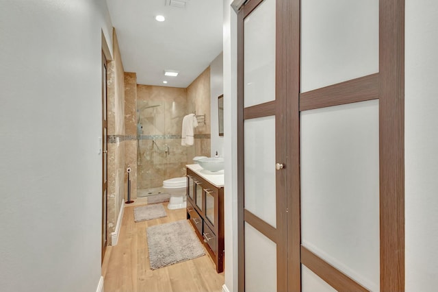 bathroom with vanity, hardwood / wood-style flooring, toilet, and walk in shower