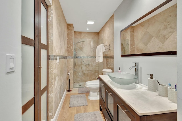 bathroom featuring vanity, hardwood / wood-style flooring, toilet, and a shower with door