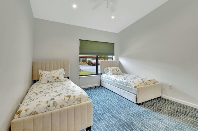 carpeted bedroom with ceiling fan and vaulted ceiling