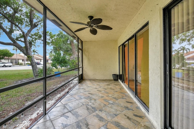 unfurnished sunroom with ceiling fan