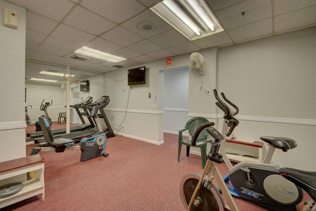 workout room featuring carpet and a drop ceiling