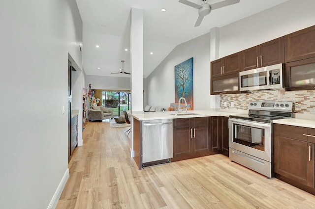 kitchen with sink, ceiling fan, appliances with stainless steel finishes, light hardwood / wood-style floors, and kitchen peninsula