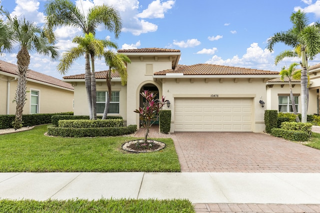 mediterranean / spanish home with a front yard and a garage