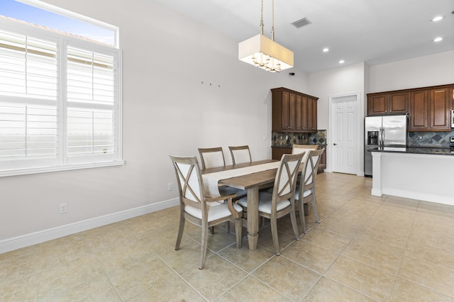 dining space featuring light tile patterned flooring and an inviting chandelier