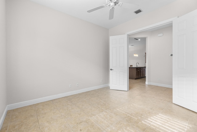 unfurnished bedroom featuring ceiling fan, sink, and light tile patterned floors