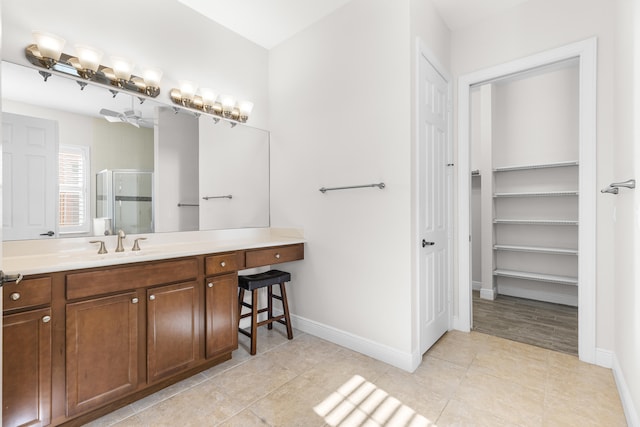 bathroom featuring tile patterned flooring, vanity, and a shower with shower door