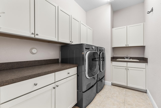 washroom with sink, light tile patterned floors, cabinets, and independent washer and dryer