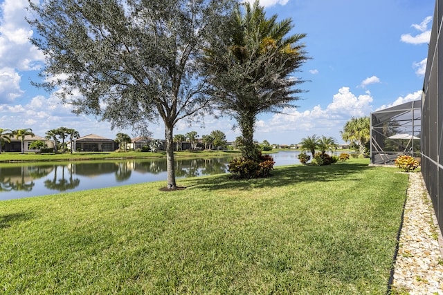 view of yard with a lanai and a water view