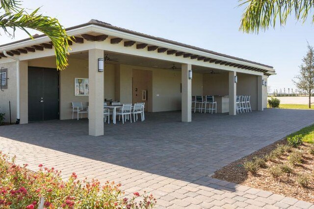 rear view of property with a patio, an outdoor bar, and ceiling fan