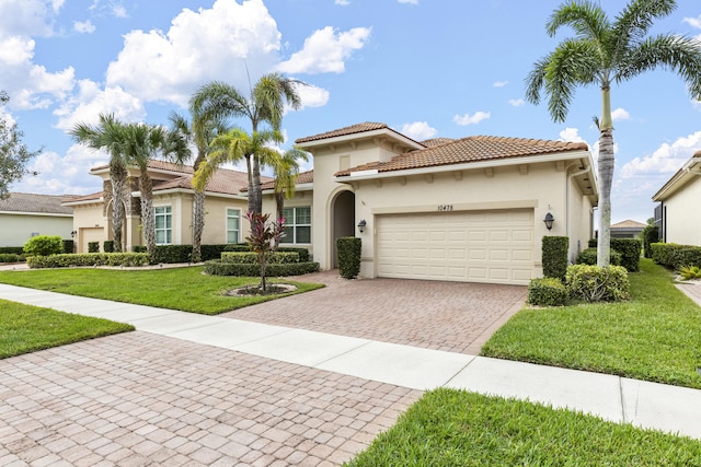 mediterranean / spanish house with a front yard and a garage