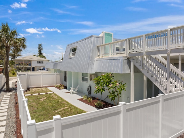 view of side of home with a yard and a balcony