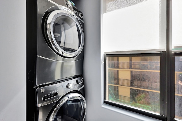 washroom featuring plenty of natural light and stacked washer / dryer