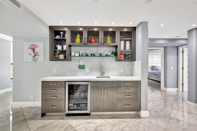 bar featuring decorative backsplash, dark brown cabinetry, sink, and wine cooler