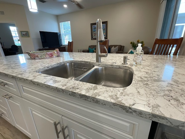 kitchen featuring light stone counters, sink, white cabinets, and hardwood / wood-style flooring