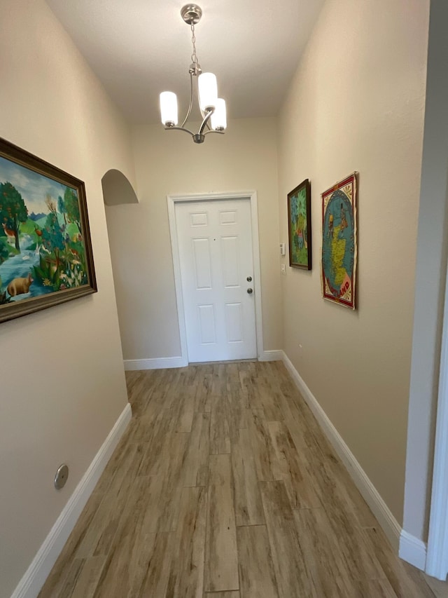 entryway featuring hardwood / wood-style floors and a notable chandelier