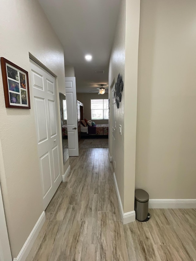 hallway with light hardwood / wood-style flooring