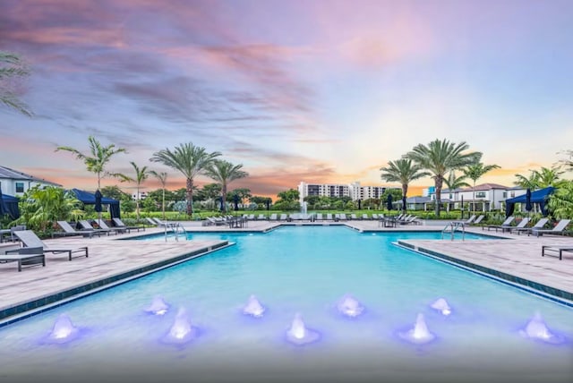 pool at dusk with a patio area