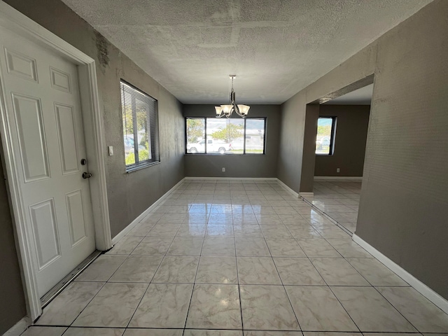 unfurnished dining area featuring a textured ceiling, an inviting chandelier, and light tile patterned flooring