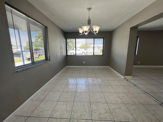 unfurnished dining area with a chandelier and light tile patterned flooring