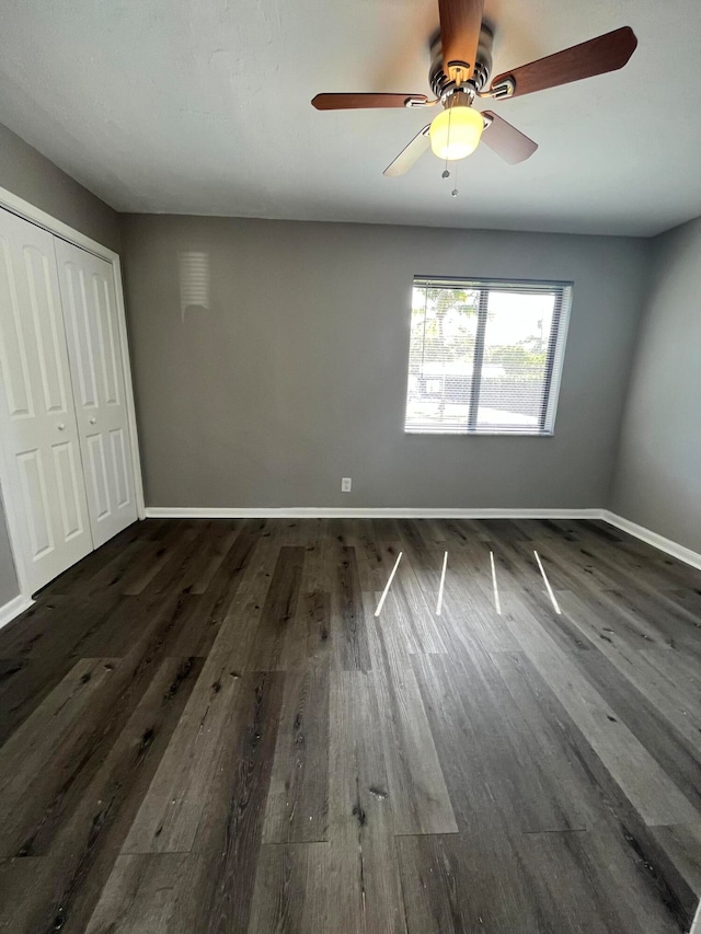 unfurnished bedroom featuring ceiling fan, a closet, and dark hardwood / wood-style floors