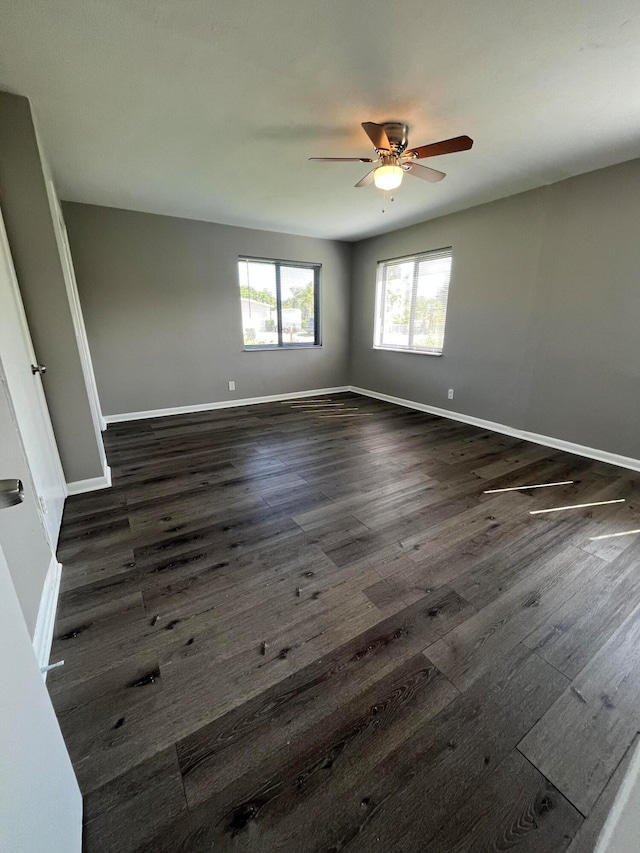 spare room with dark hardwood / wood-style floors and ceiling fan