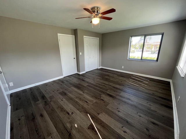 unfurnished bedroom featuring ceiling fan and dark wood-type flooring