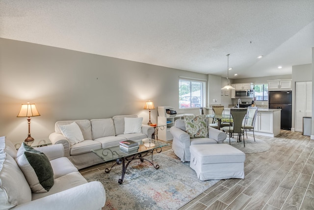 living room with a textured ceiling and light wood-type flooring