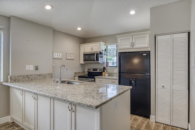 kitchen featuring white cabinetry, sink, kitchen peninsula, and stainless steel appliances