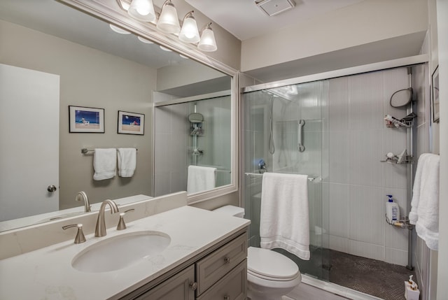 bathroom featuring vanity, toilet, and an enclosed shower