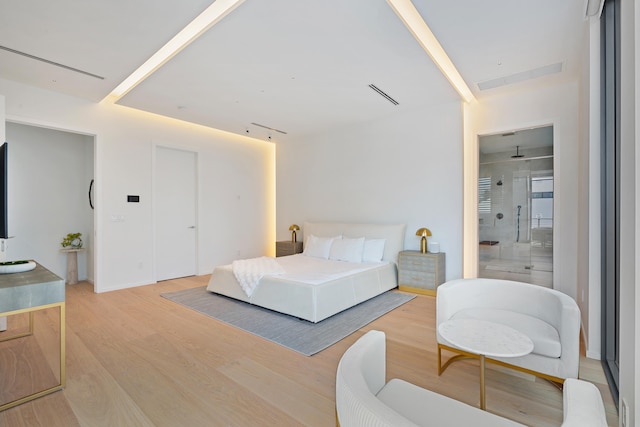 bedroom featuring light wood-type flooring and ensuite bathroom