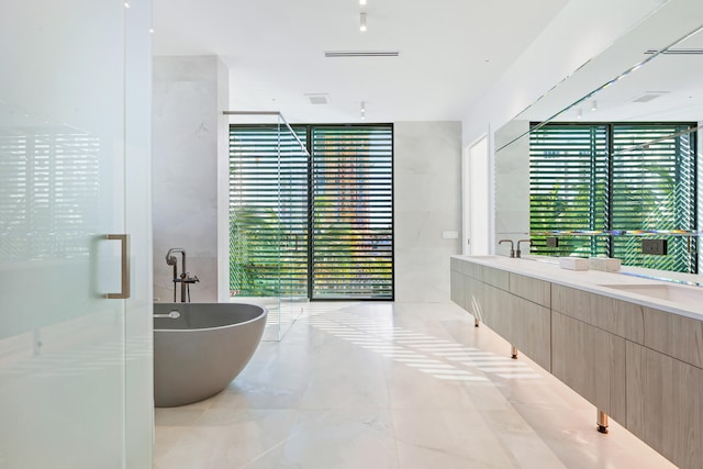 bathroom featuring floor to ceiling windows, vanity, and independent shower and bath