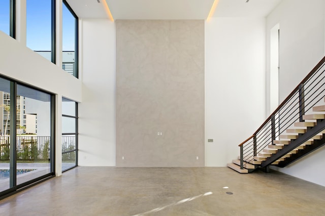 interior space with a towering ceiling and concrete floors