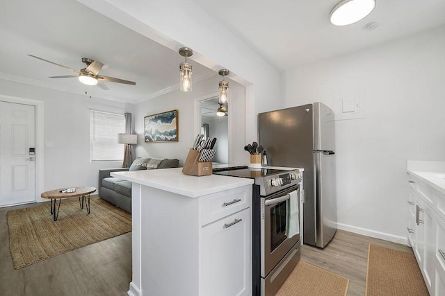 kitchen featuring appliances with stainless steel finishes, decorative light fixtures, light wood-type flooring, and white cabinets