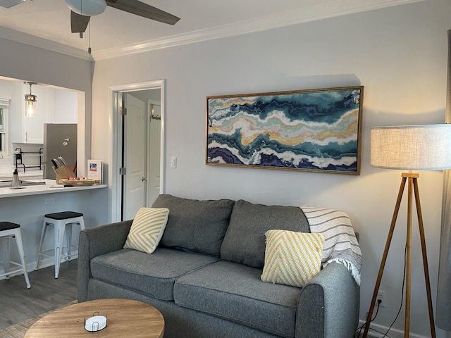 living room featuring hardwood / wood-style flooring, ceiling fan, and ornamental molding