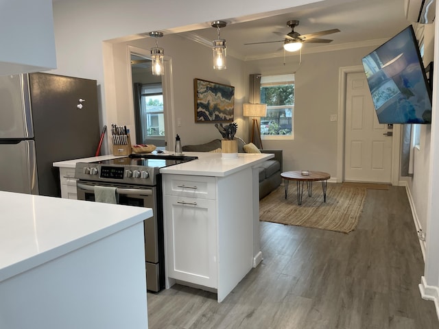 kitchen featuring white cabinetry, appliances with stainless steel finishes, light wood-type flooring, and pendant lighting