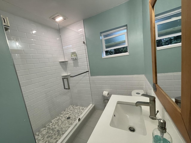 bathroom with tile walls, sink, a shower with shower door, and tile patterned floors