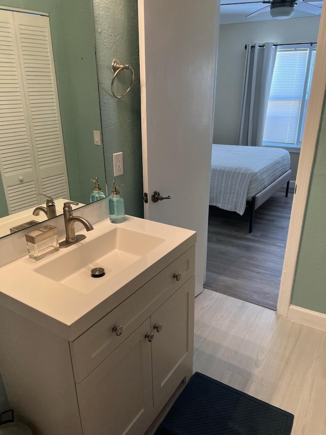 bathroom featuring hardwood / wood-style flooring, ceiling fan, and vanity