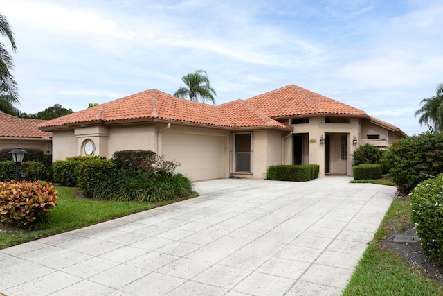 2843 SW Mariposa Cir, Palm City, FL 34990 - mediterranean / spanish home featuring stucco siding, driveway, a tiled roof, and an attached garage