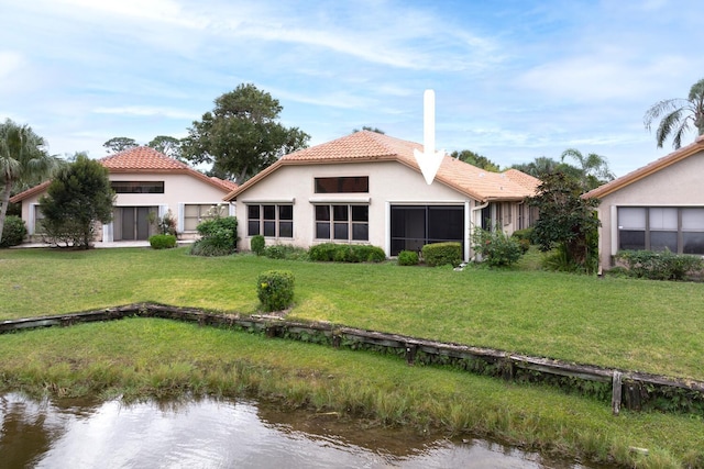 2843 SW Mariposa Cir, Palm City, FL 34990 - rear view of house with a tiled roof, stucco siding, a water view, and a lawn