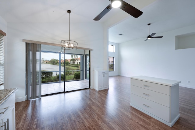 2843 SW Mariposa Cir, Palm City, FL 34990 - unfurnished living room with a ceiling fan, dark wood-style flooring, high vaulted ceiling, baseboards, and a chandelier