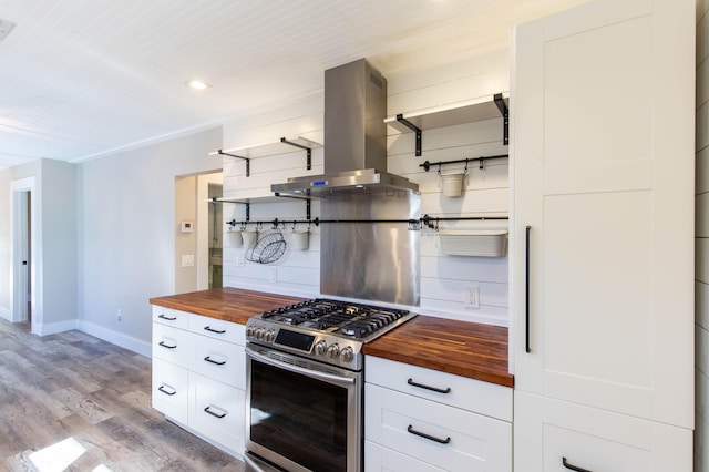 kitchen with white cabinetry, stainless steel gas range oven, butcher block countertops, light hardwood / wood-style floors, and island range hood