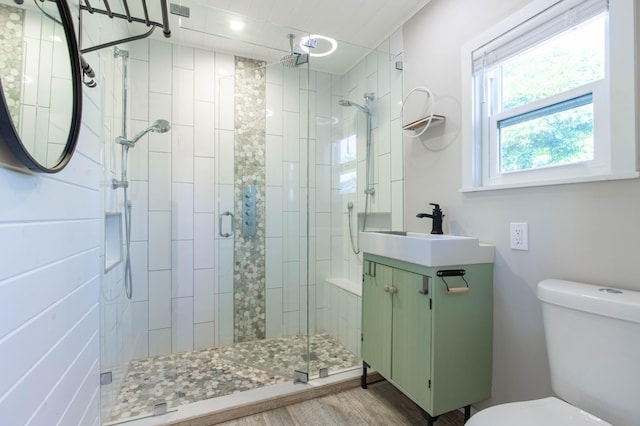 bathroom featuring vanity, hardwood / wood-style flooring, toilet, and an enclosed shower