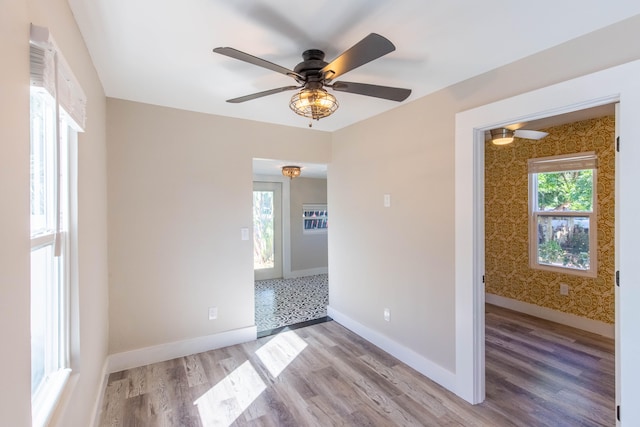 unfurnished room featuring hardwood / wood-style floors, plenty of natural light, and ceiling fan