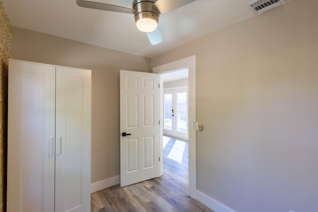 unfurnished bedroom featuring ceiling fan, light hardwood / wood-style floors, and a closet