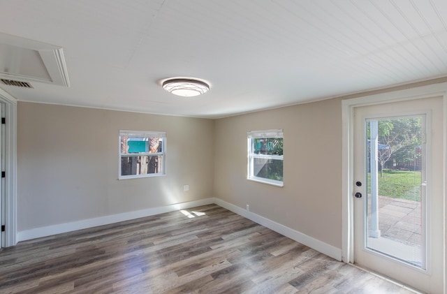 spare room with hardwood / wood-style flooring and a healthy amount of sunlight