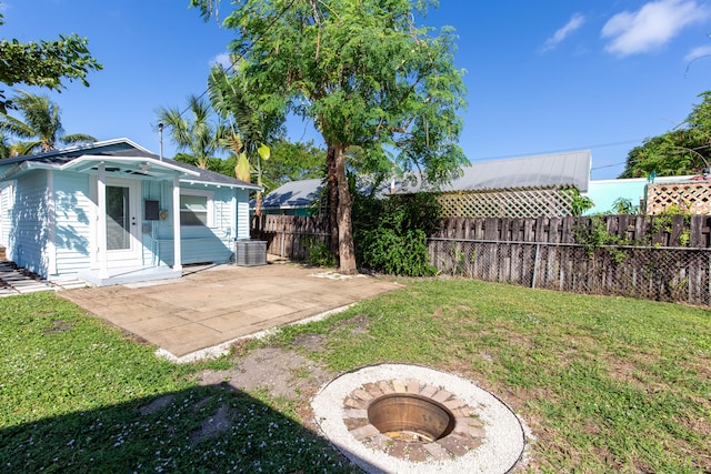 view of yard with a patio area, a fire pit, and central AC