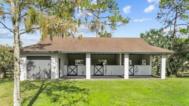 rear view of house with a yard and a garage